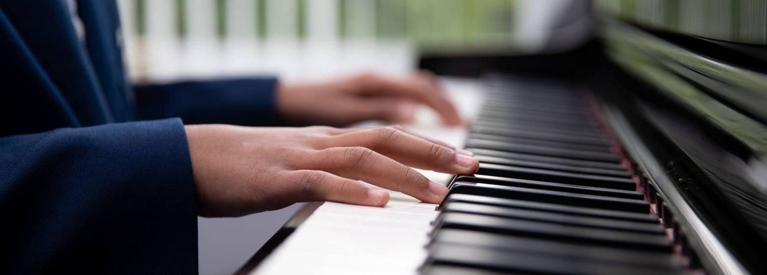 close up of child's hands playing piano