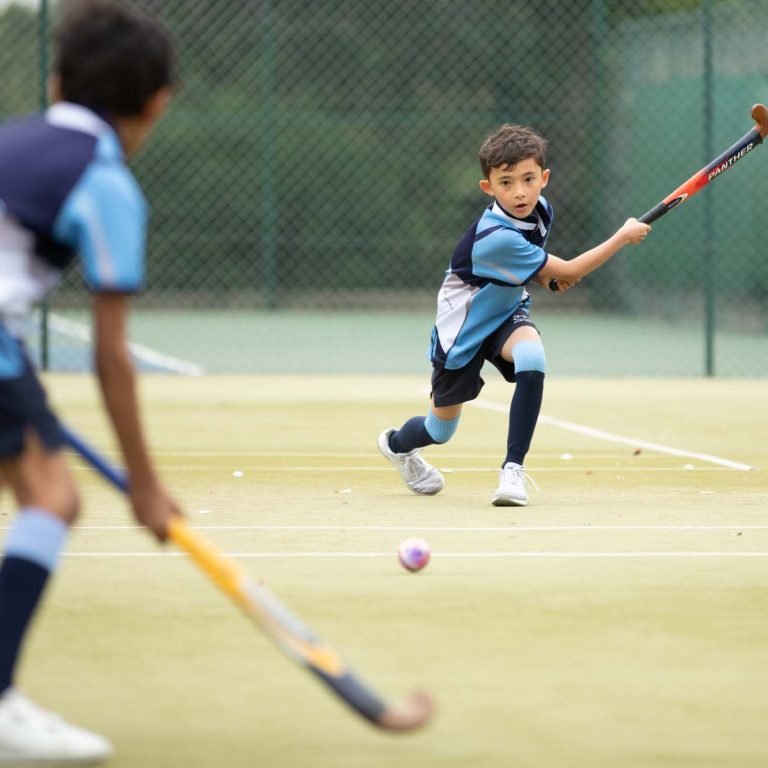 children running with hockey sticks