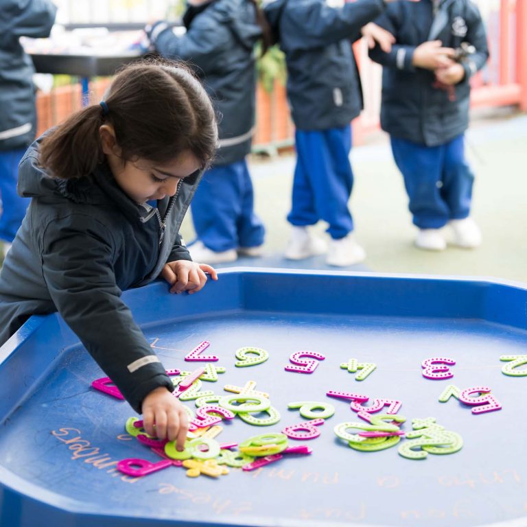 child rearranging letters and numbers