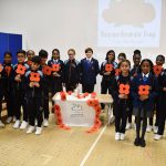 Students hold up poppies for Remembrance Day