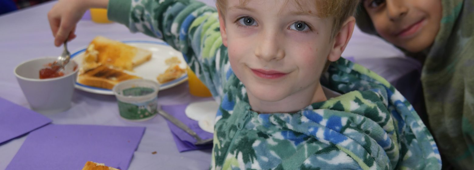 Student putting jam on his toast