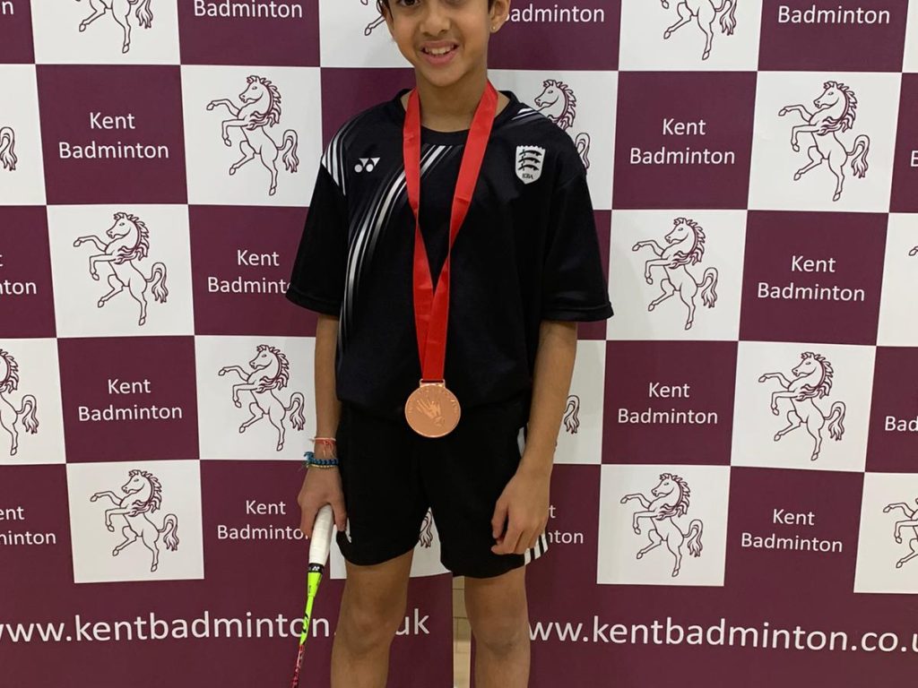 girl in front of banners with a medal on