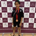 girl in front of banners with a medal on