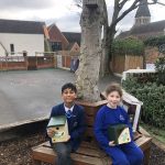 girl and boy holding bird boxes