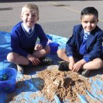 pupils sat in sand