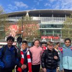 Students standing outside a football stadium