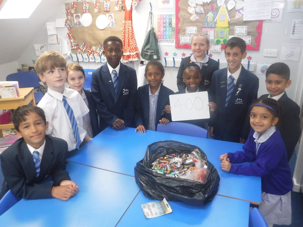students around a bag of old batteries