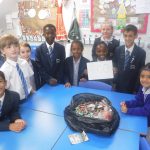 students around a bag of old batteries