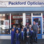 students in front of an opticians