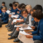 students holding worksheets