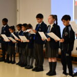 students holding sheets of paper