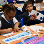 students cutting and sticking