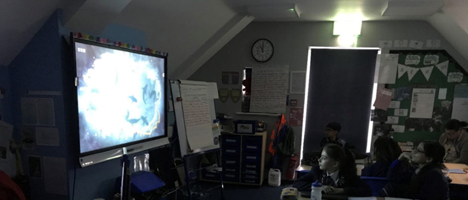 students in the dark watching a science documenary