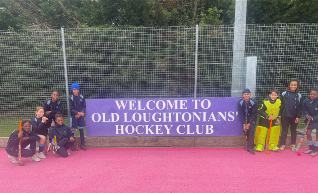 school hockey team posing by a sign