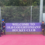 school hockey team posing by a sign