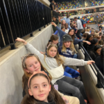 group of school students sitting in a row at a sporting event