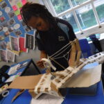 school student creating a model bridge