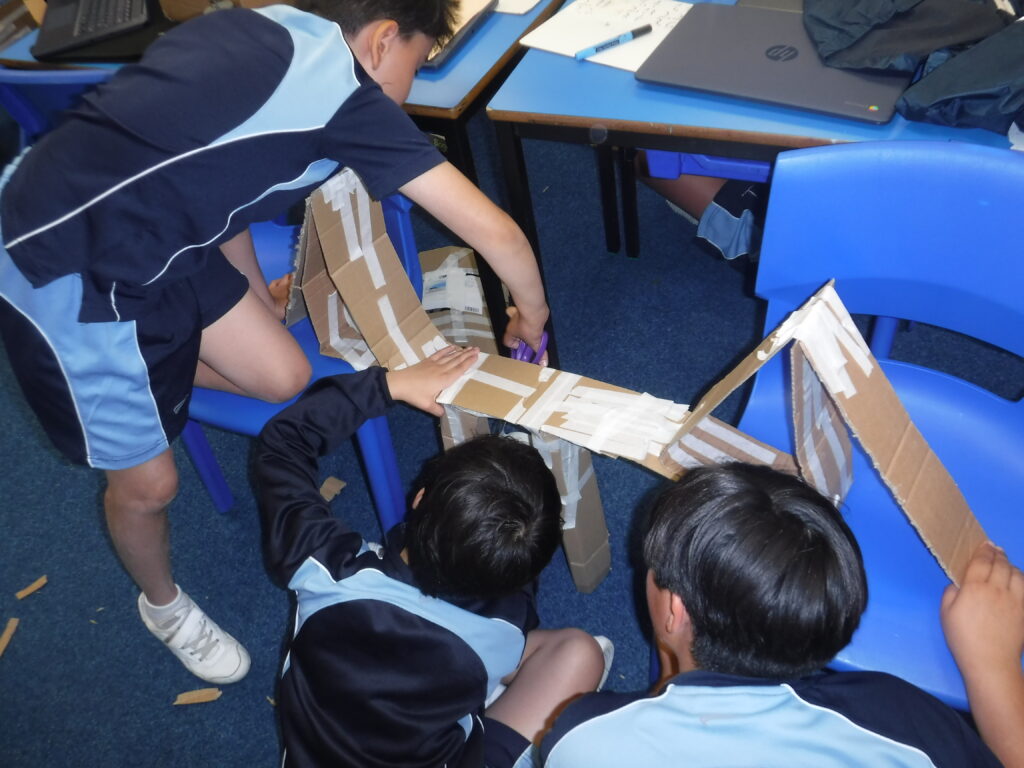 group of school boys building a model bridge