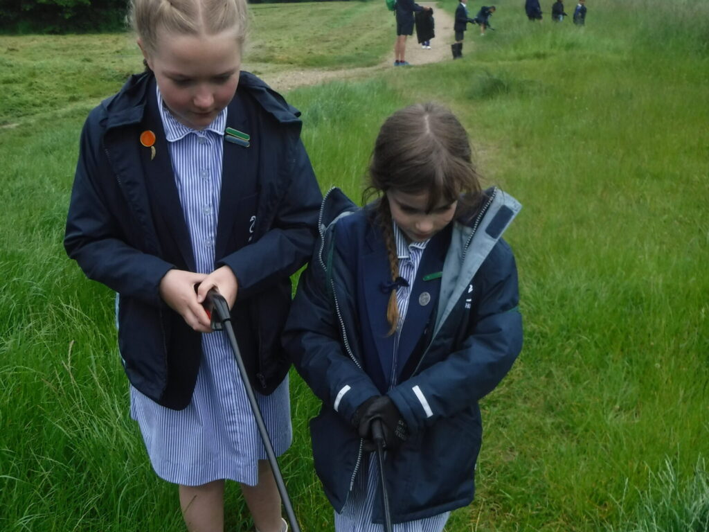 two school girls picking up litter