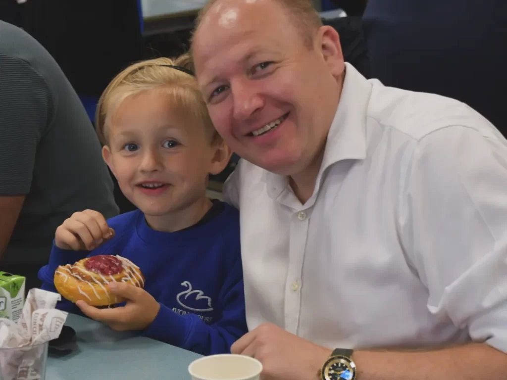 students eating a pastry with his dad
