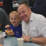 students eating a pastry with his dad