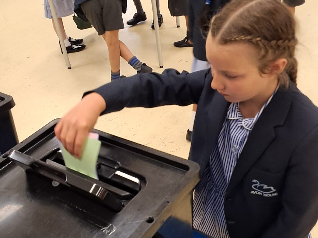 student putting a paper in a box