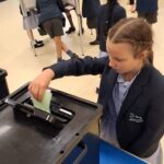 student putting a paper in a box
