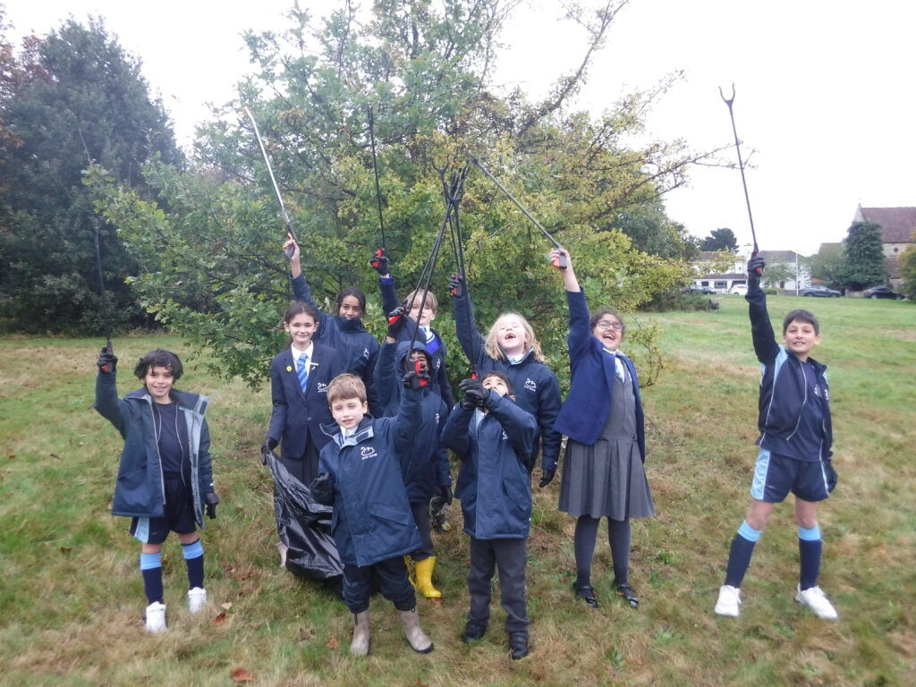 students holding litter pickers